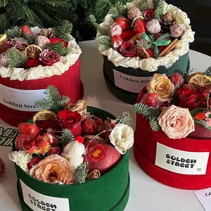Christmas round flower gift boxes in red and green with roses, strawberries and ornaments