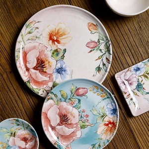 Floral 9-inch ceramic dinner plate set with watercolor patterns on a wooden table