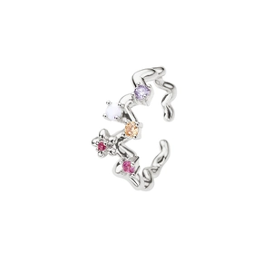 Détail macro du耳cuff en argent avec zircons colorés au design ondulé irrégulier