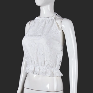 Close-up of white halter neck crop top with intricate lace embroidery and elastic hem