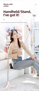 Pink multi-functional selfie stick with tripod stand used by model in an outdoor setting