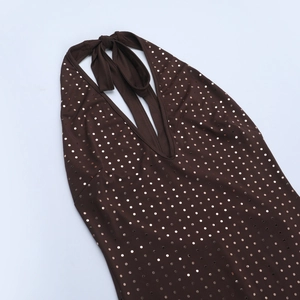 Detail of dark brown halter neck jumpsuit featuring shimmering gold metallic polka dot sequins