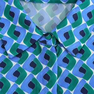 Détail du col à revers sur un chemisier à manches longues aux motifs géométriques bleus