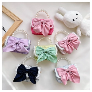 Detailed view of tweed mini bags with pearl handles and decorative ribbon bows