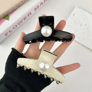 Elegant black and beige hair claws with large pearl accents for a sophisticated look