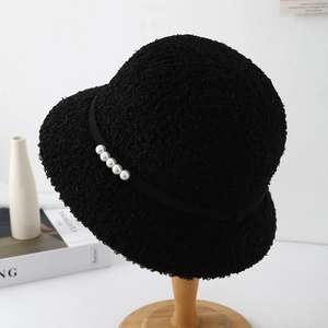 Détail de la texture du bob noir en laine d'agneau avec élégantes perles blanches