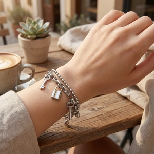Double-layered titanium steel bracelet with padlock and key charms in silver finish