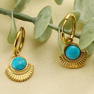 Macro shot of 18K gold plated fan-shaped earrings inlaid with round turquoise stones