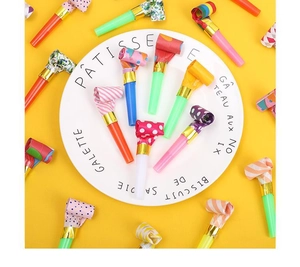 Assorted colorful party blowouts with patterns arranged in a white decorative dish