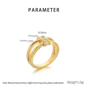 Detail of 18K gold-plated knotted cross ring with rhinestones and rope texture