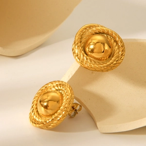Detailed close-up of 18k gold plated round twisted earrings on a ceramic background