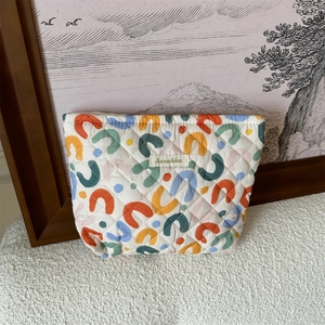 Detailed view of quilted cotton cosmetic bag with colorful U-shaped geometric patterns