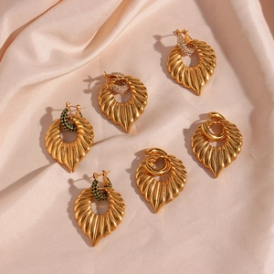 Elegant 18K gold plated leaf earrings set with sparkling crystals on silk background