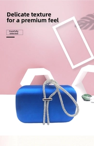 Detail view of royal blue satin evening clutch with sparkling rhinestone circular handle