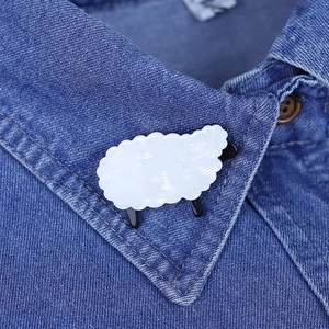 Cute white acrylic sheep brooch pinned on a blue denim shirt collar with black accents