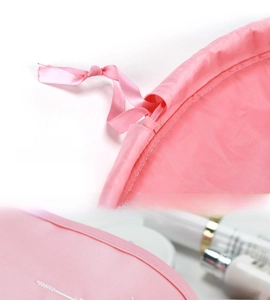Macro detail of the durable pink drawstring and white embroidered logo on travel makeup bag