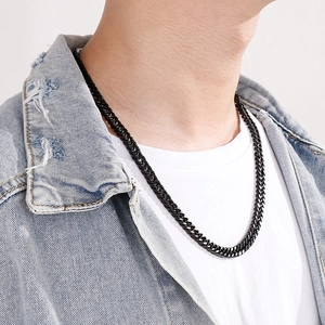 Close-up of a classic black stainless steel NK chain necklace worn by a male model