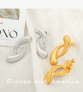 Macro shot of twisted geometric hoop earrings in 18k gold and silver plated titanium steel