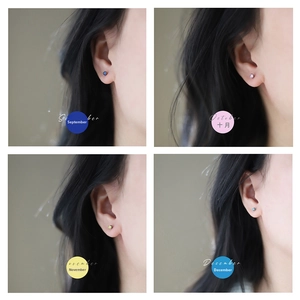 Detailed view of four birthstone stud earrings in blue, pink, green, and sky blue crystals