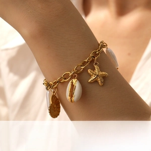 Detail of gold-plated starfish and shell charms on a chunky stainless steel link chain