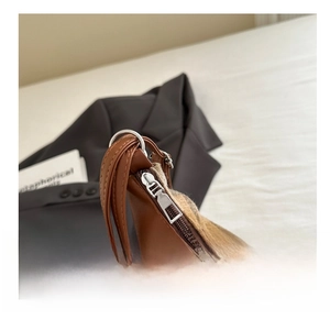 Detailed macro view of smooth metal zipper and brown plaid fabric of the tote bag