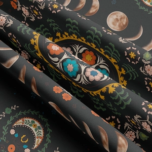 Macro detail of dark grey moon phase tapestry fabric with bohemian floral patterns