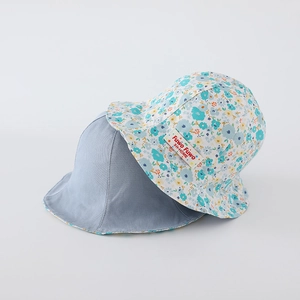 Détail du chapeau de soleil réversible pour bébé avec motif floral et tissu en coton doux