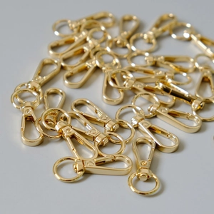 Pile of polished gold metal lobster clasps for bags and DIY keychain accessories
