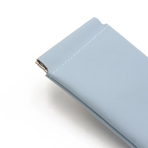 Light blue lychee texture leather sunglasses pouch with white stitching and spring closure