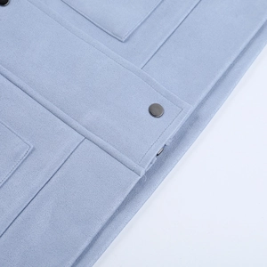 Detail of light blue casual jacket showing heavy fabric texture and metal snap button