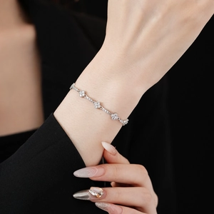 Close-up of model wearing silver diamond clover bracelet with sparkling zircon flowers