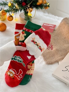 Close-up of festive Christmas socks featuring Santa Claus and reindeer in red and green colors