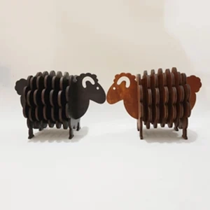 Detail of sheep-shaped wooden coasters in black and dark brown wood for table decor