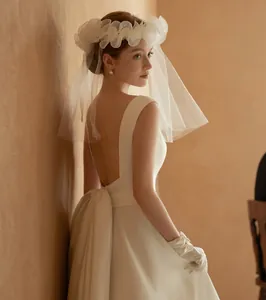 Close-up of elegant bridal veil with 3D floral details and satin wedding dress back view
