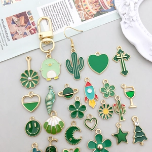 Détail de breloques en émail vert avec fleurs et cactus pour la création de bijoux DIY