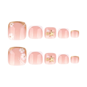 Faux ongles d'orteils dorés et blancs avec motifs floraux et breloques étoile de mer