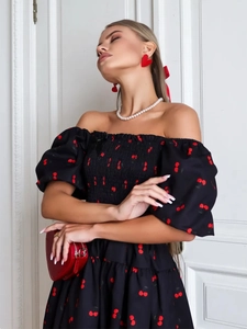 Detail of square neck puff sleeves and red cherry print on this black summer mini dress