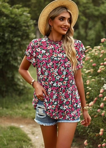 Detail of floral print short sleeve blouse with delicate flutter sleeves in a garden
