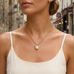 Elegant freshwater pearl pendant necklace with gold bowknot design and sparkling crystals