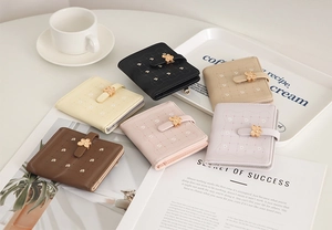 Flat lay of multiple color PU leather floral stitch wallets with gold flower buckles