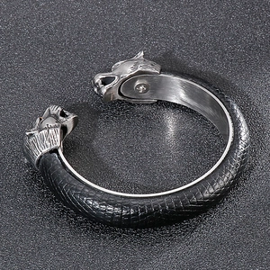 Detail of viking wolf head stainless steel bracelet with scale texture leather band