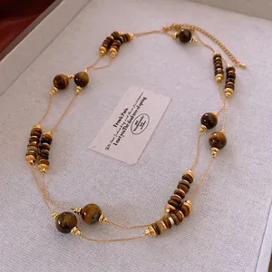 Double-layered gold necklace with brown tiger eye beads for vintage fall sweater styling
