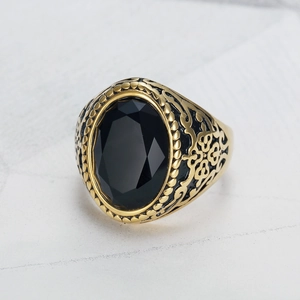 Detailansicht eines klassischen Gold-Titanstahlrings für Herren mit großem schwarzem Edelstein
