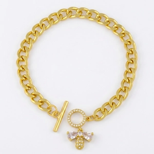 Golden Cuban link bracelet with bee charm and crystal toggle clasp on white background