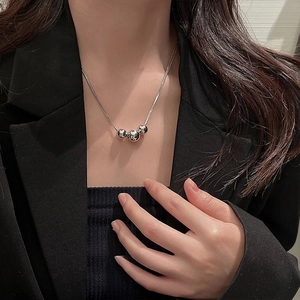 Detailed view of silver triple metal beads on a sleek minimalist necklace chain