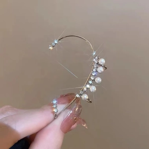 Elegant silver ear cuff with sparkling diamonds and white pearls in a minimalist design