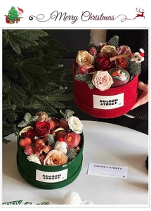 Close-up of a Christmas flower box with red velvet finish, roses, and fresh strawberries