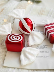 Close-up of red and white striped Christmas candy ornaments with glitter on a warm background