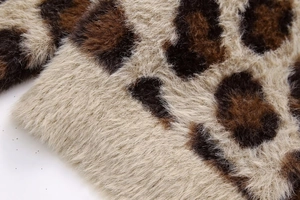 Detailaufnahme von weichem Plüschstoff mit Leopardenmuster in Braun und Beige