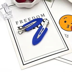 Detail showing 5.9cm leaf-shaped navy blue hair clips with duckbill metal base